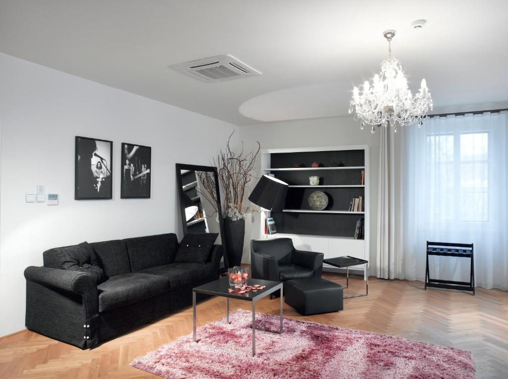 a living room with a black couch and a table at Hotel Aplaus in Litomyšl