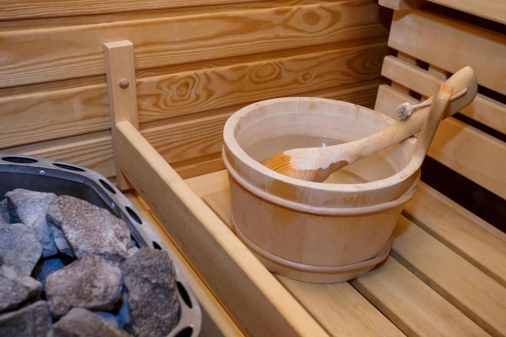 a bucket of water in a sauna with rocks at Hotel Aplaus in Litomyšl