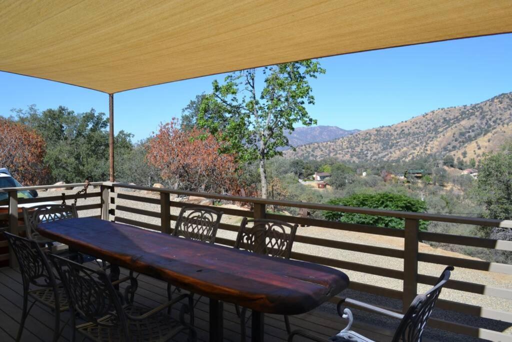 a wooden table and chairs on a deck with a view at In The Oaks in Three Rivers