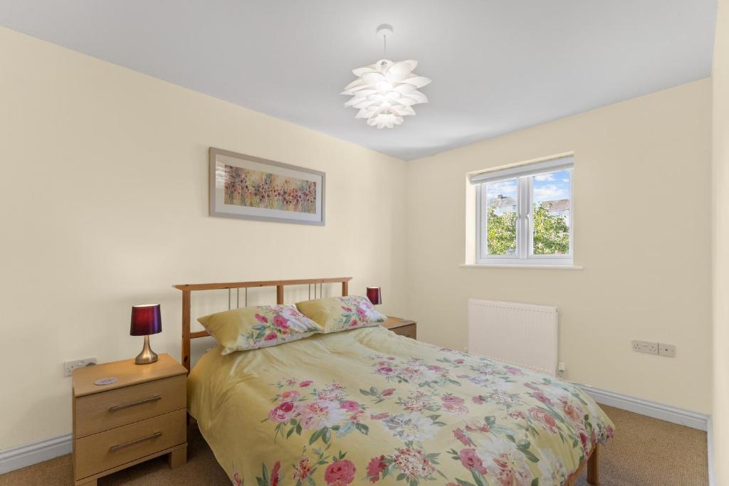een slaapkamer met een bed, een dressoir en een raam bij The Pink House, Paignton in Paignton