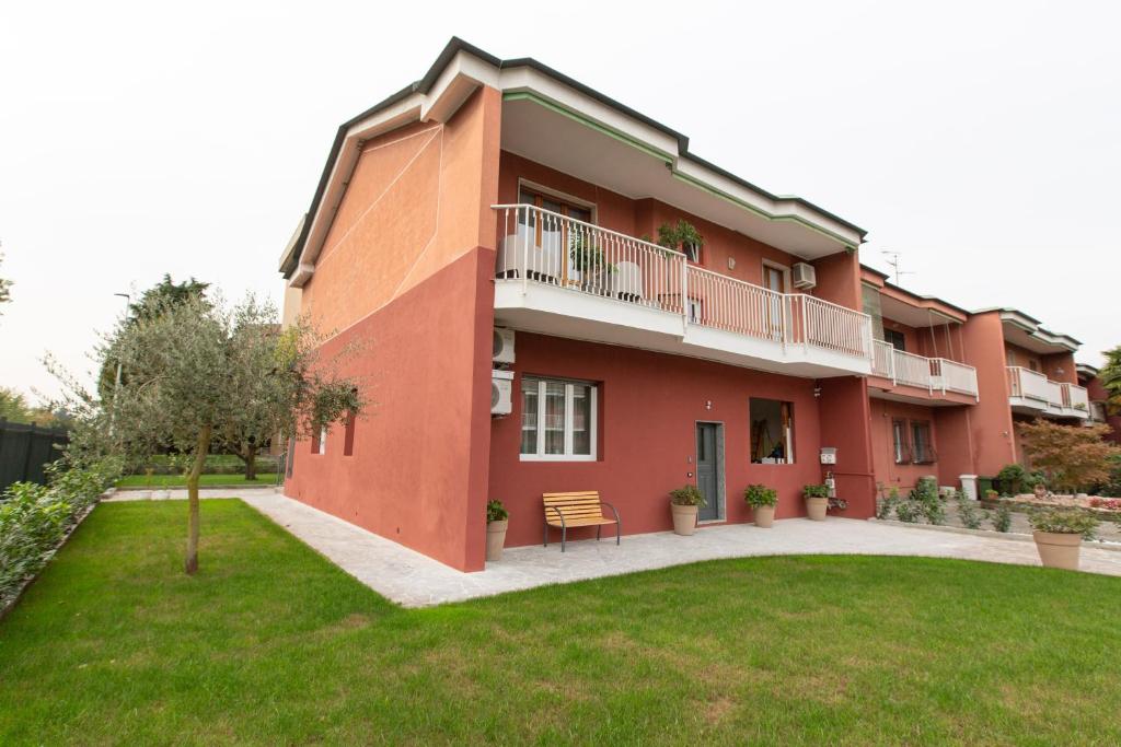 un grand bâtiment rouge avec une pelouse devant lui dans l'établissement Relax nel Verde, à Segrate