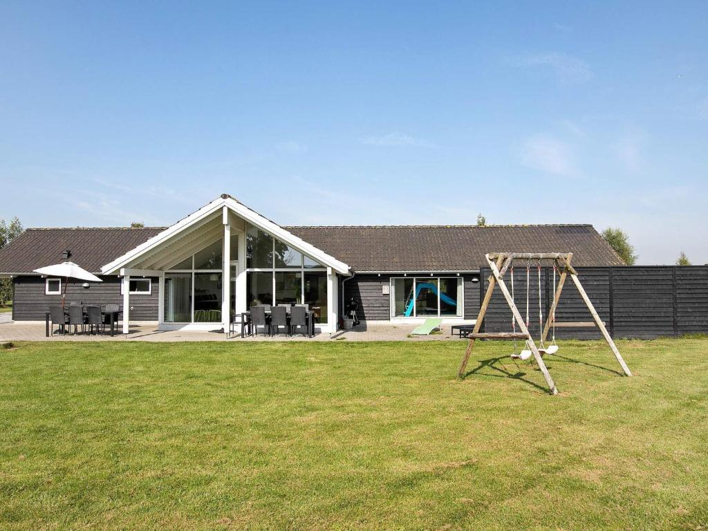 una casa con un patio con un columpio en 14 person holiday home in Idestrup, en Bøtø By