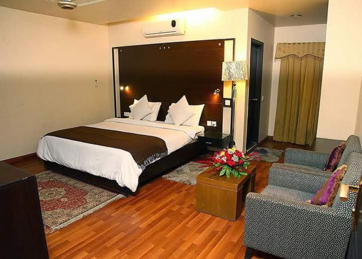 a hotel room with a bed and a living room at Hira Guest House in Karachi