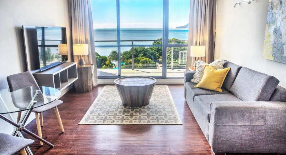 a living room with a couch and a large window at Cairns Plaza Hotel in Cairns