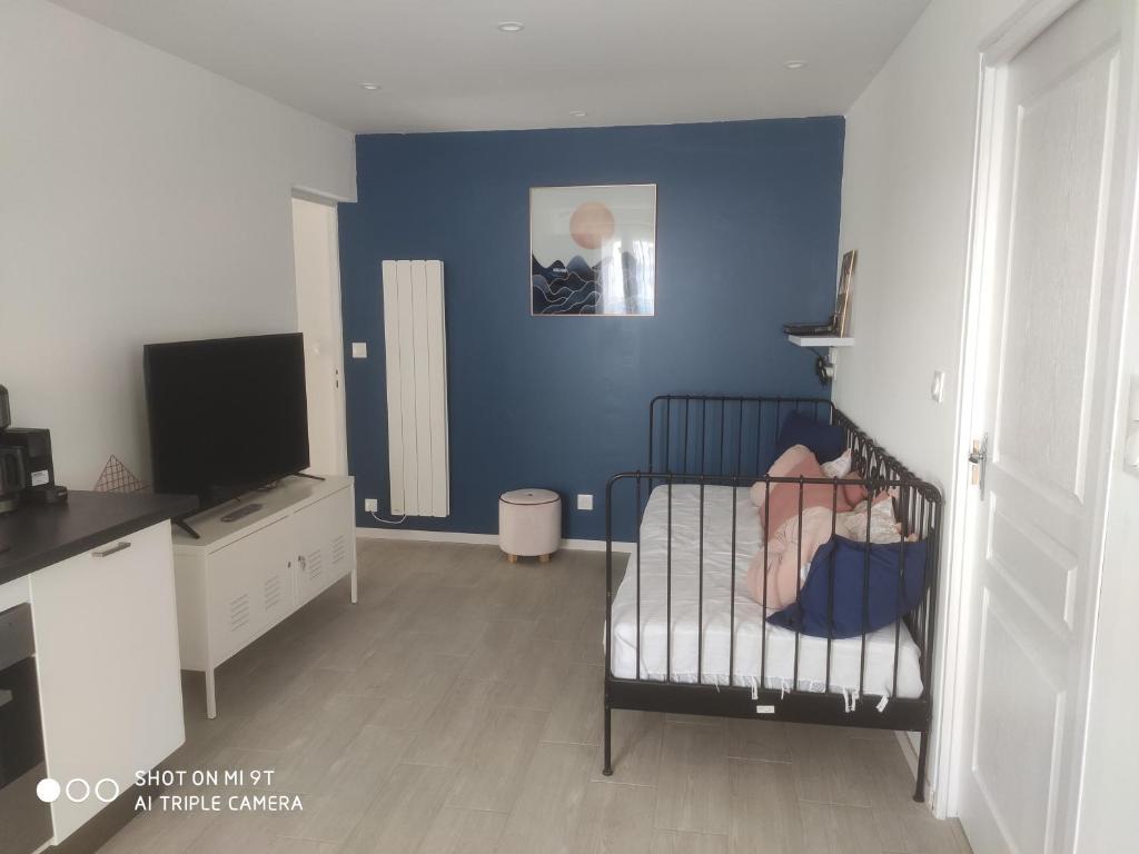 Cuna en habitación con pared azul en Little baie, en Pleine-Fougères