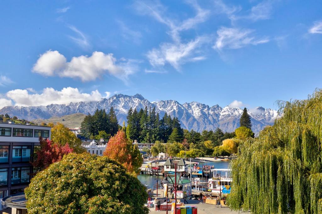 uma cidade com um porto com montanhas ao fundo em Heart of Queenstown em Queenstown