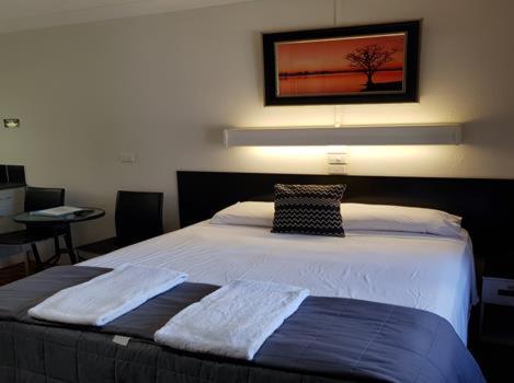 um quarto com uma cama com duas toalhas em Motel Lodge em Rockhampton