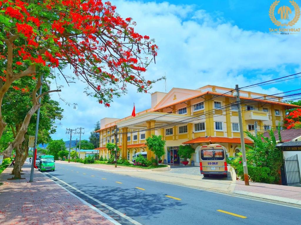 a bus parked on the side of a street with a yellow building at Tan Son Nhat Con Dao Resort in Con Dao