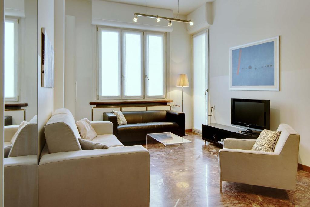 ein Wohnzimmer mit Sofas und einem Flachbild-TV in der Unterkunft Milan Apartment Rental in Mailand
