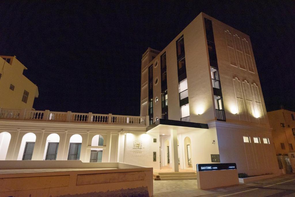 a large white building with a balcony at night at Day Time Travel B&B 登記編號1033 in Magong