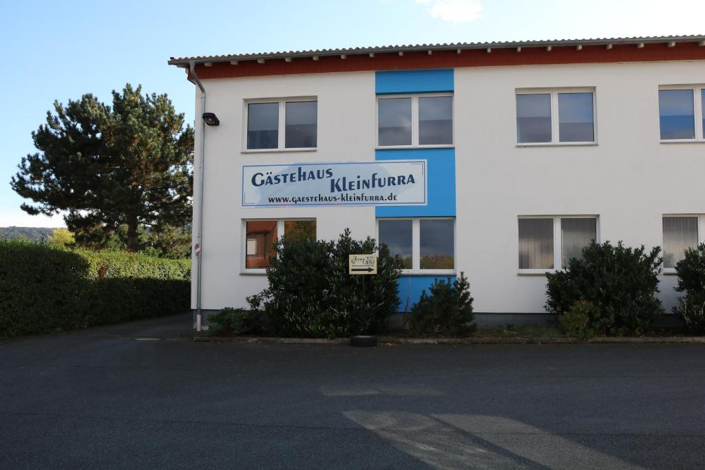 a white building with a sign on the side of it at Gästehaus Kleinfurra in Kleinfurra