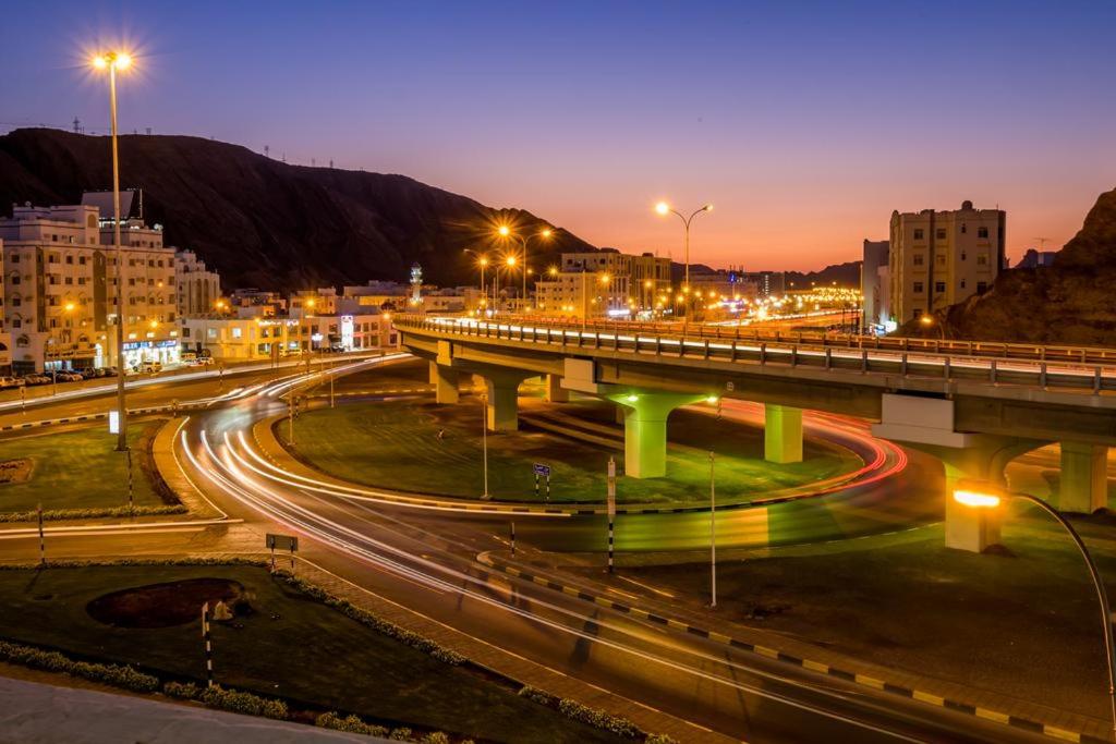a bridge over a highway at night with cars at Al Jisr Hotel in Muscat
