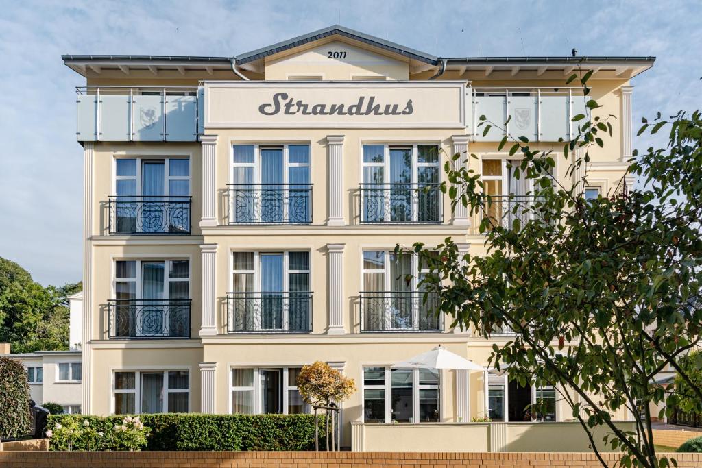 a building with a sign that reads sanctums at Aparthotel Strandhus in Ahlbeck