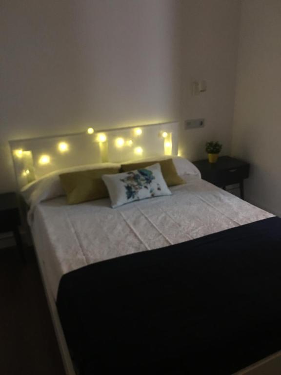 a bedroom with a bed with lights on it at Apartamento Urquijo in Granada