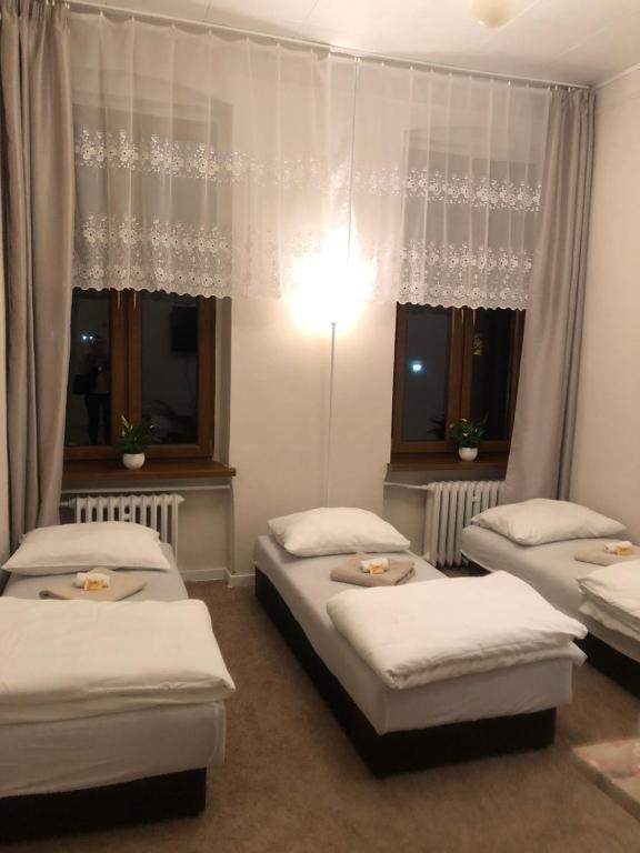 グリフィツェにあるHotel Gryfのベッドルーム1室(ベッド3台、窓2つ付)