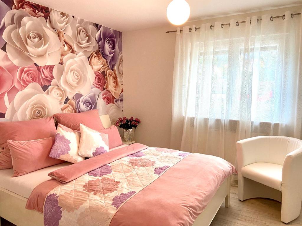 a bedroom with a bed with a floral wall at Ferienwohnung Kuhn in Ettenheim
