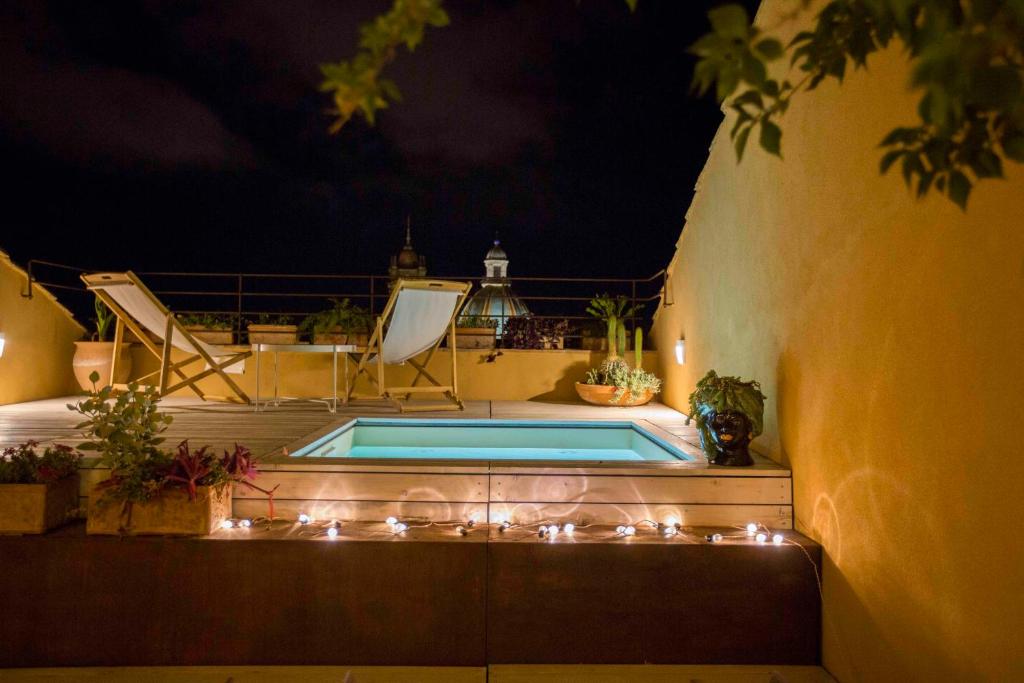 una piscina con luces en un patio por la noche en B&B Attico Taranto, en Caltagirone