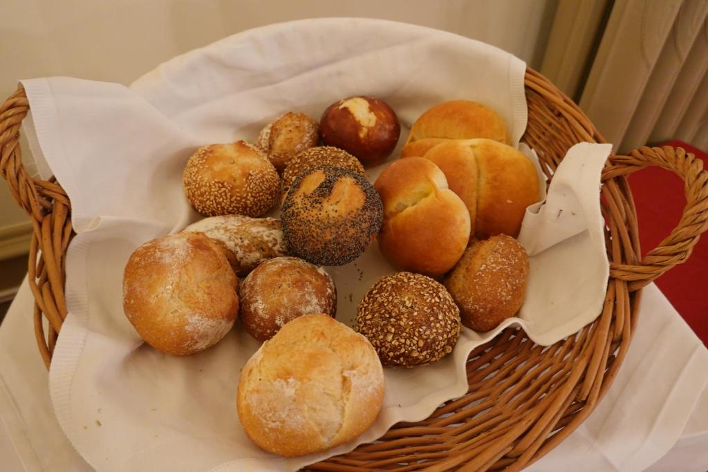 a basket of different types of donuts on a table at Hotel Schweizerhof in Engelberg