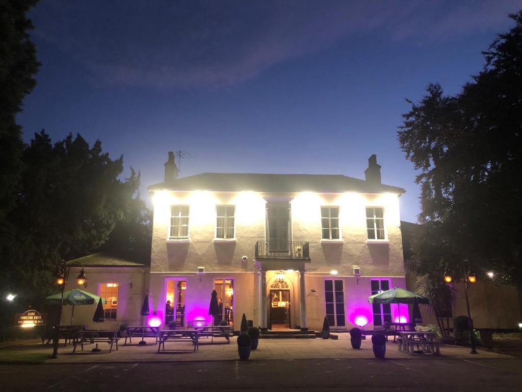 a large white building with lights on it at night at The Elms Hotel in East Retford