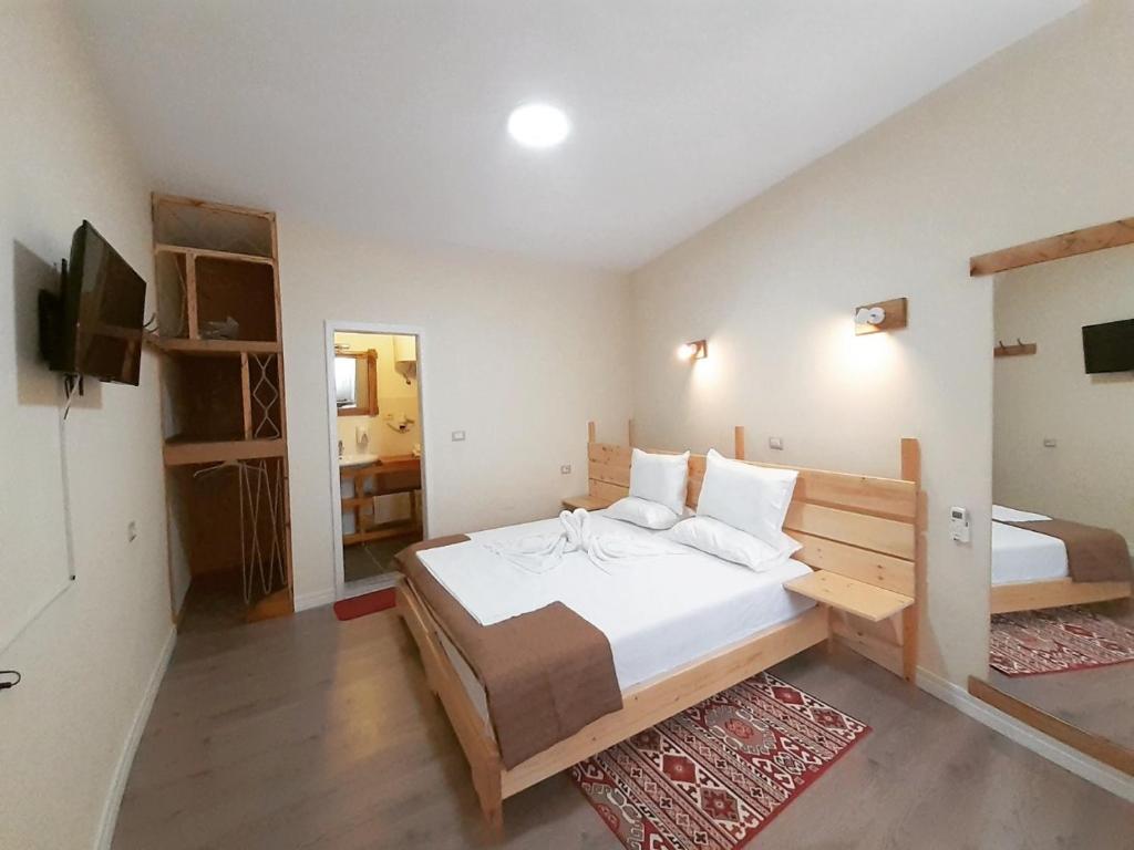 1 dormitorio con 1 cama grande y TV en At Pikotiko's - Korca City Rooms for Rent en Korçë
