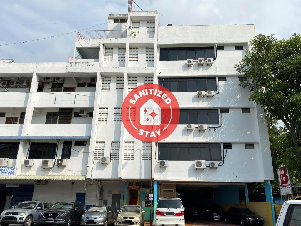 a white building with a red sign on it at OYO 89540 B Hotel Penang in Bayan Lepas