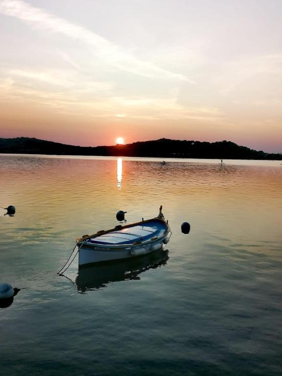 a small boat sitting in the water at sunset at Villa Roka in Six-Fours-les-Plages