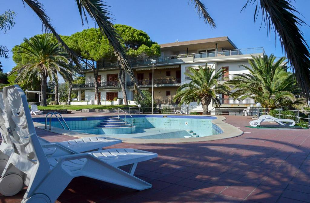 basen z krzesłem i budynek w obiekcie Paradise Beach w mieście Giardini Naxos