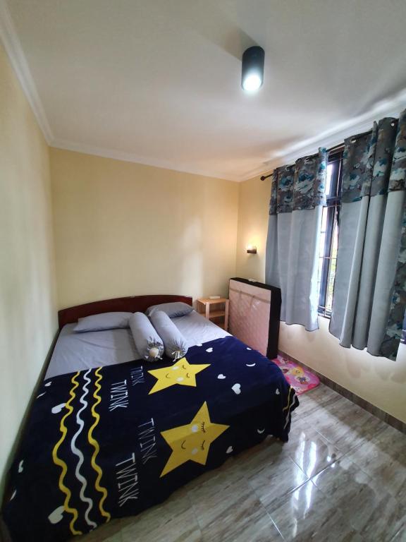 a bedroom with a bed with stars on it at VILLA PANDA G Kota Bunga Puncak in Cinengangirang