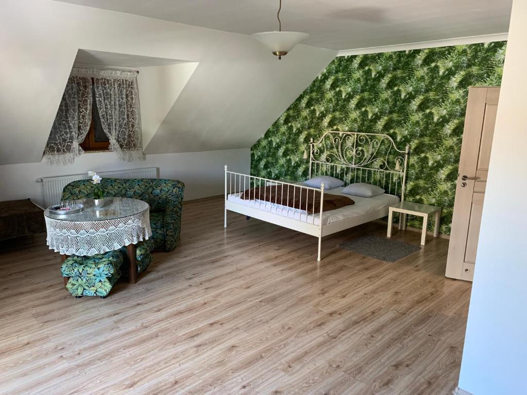 Motel u Olka في Boczów: غرفة بها سرير أطفال وكراسي وجدار أخضر