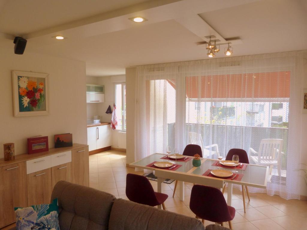 un salon avec une table et des chaises et une cuisine dans l'établissement GITE LA HOUBLONNIÈRE STANDING et CONFORT à COLMAR, à Colmar