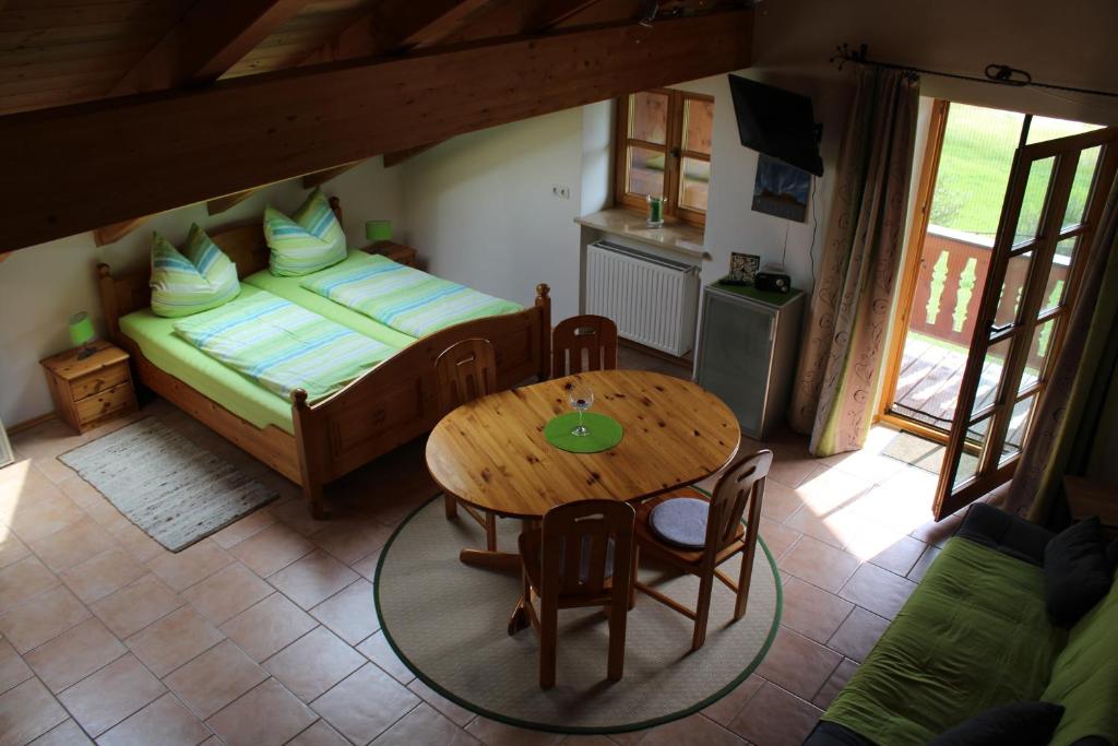 ein kleines Zimmer mit einem Tisch und einem Bett in der Unterkunft Biohof Babel in Sachsenkam