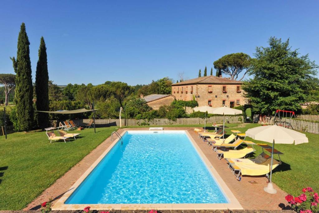 una piscina con sedie e ombrelloni e una casa di 9 bedrooms villa with private pool enclosed garden and wifi at Monteroni d'Arbia a Monteroni dʼArbia