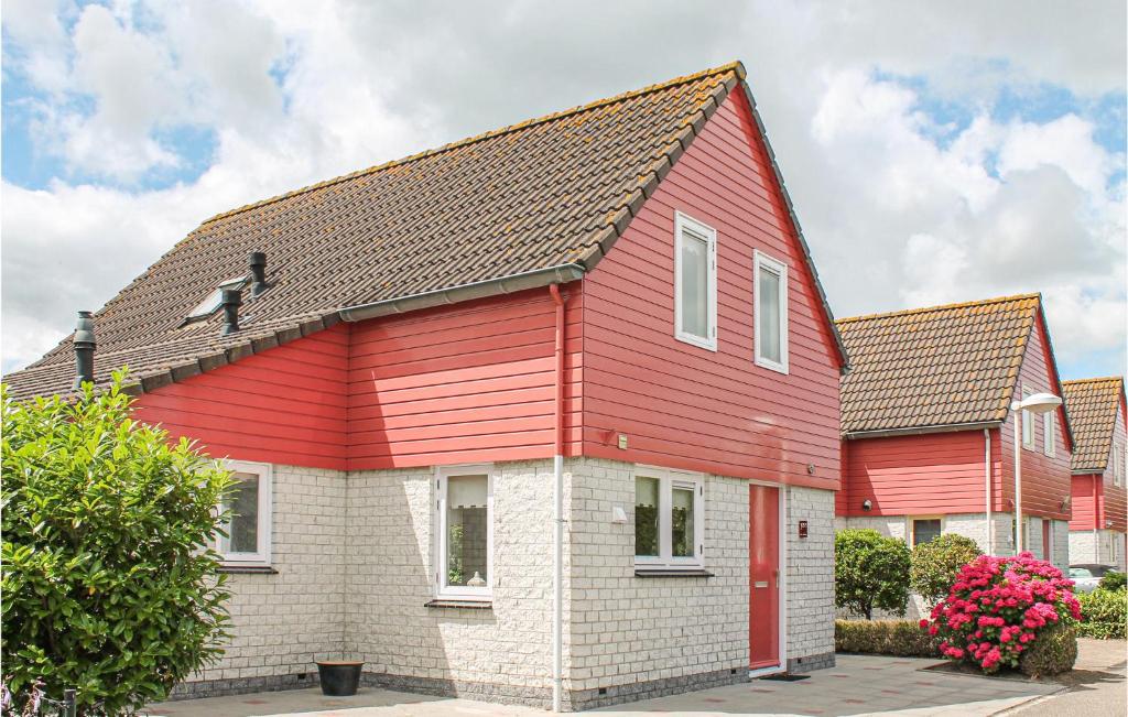 a red house with a dog on the roof at 4 Bedroom Gorgeous Home In Wemeldinge in Wemeldinge