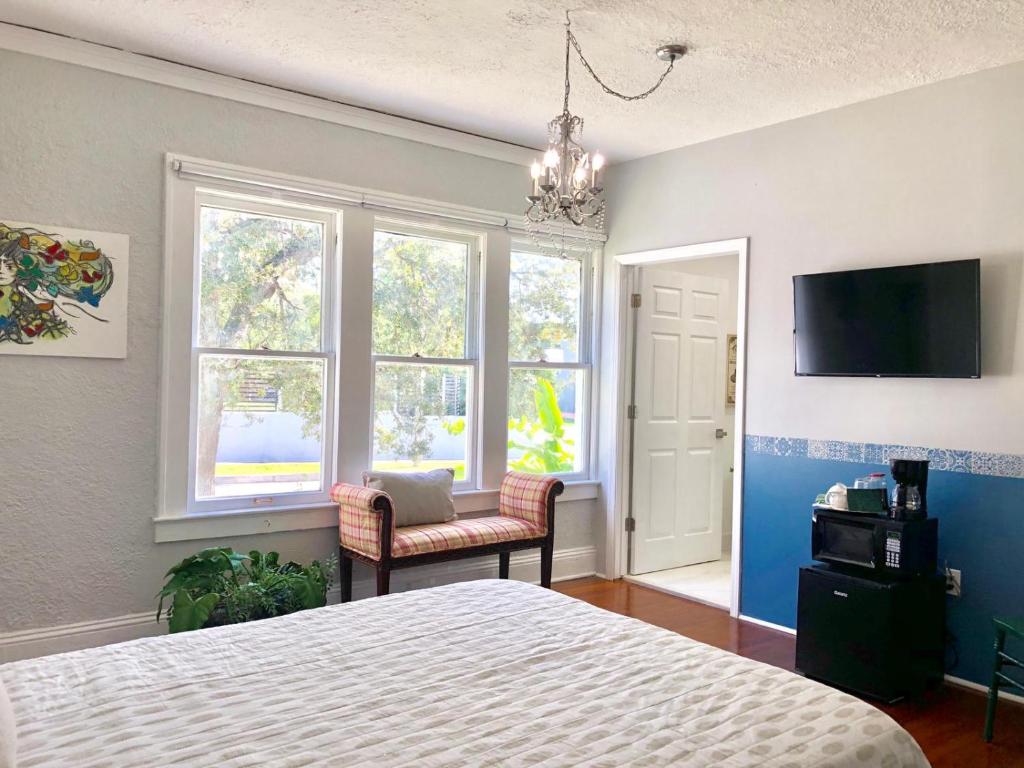 a bedroom with a bed and a tv and windows at Comfy and Spacious Suite with Free Parking - 2G in Miami