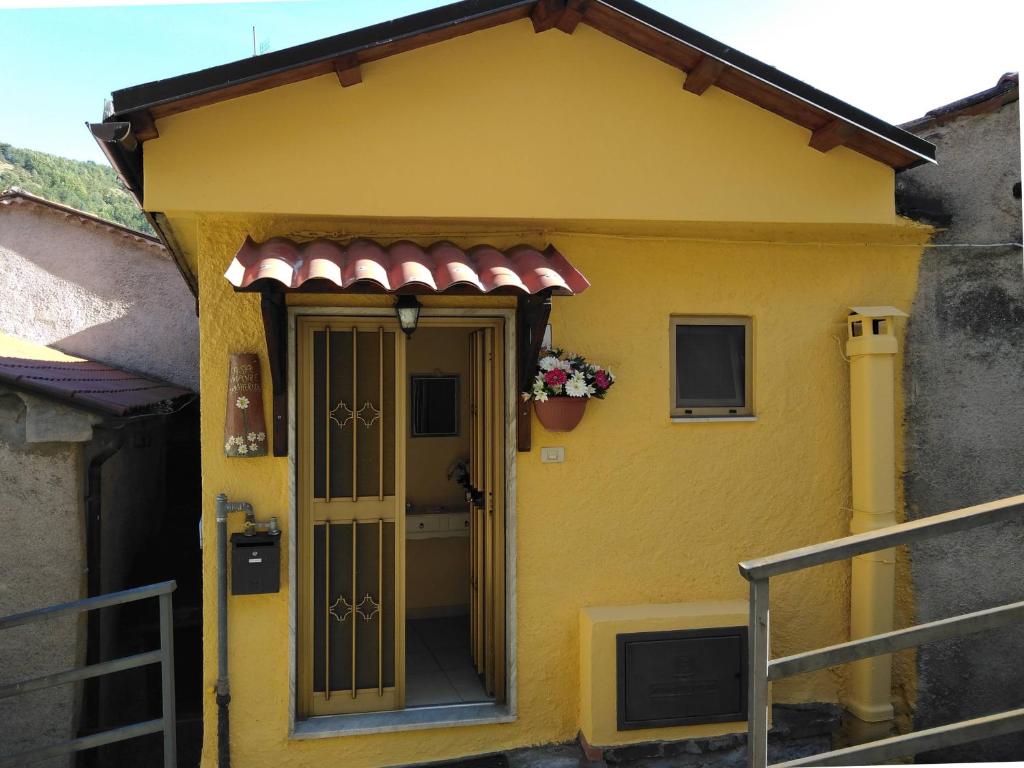 ein gelbes Haus mit einer Tür und einem Blumentopf in der Unterkunft Casa Vacanze Margherita - Sasso di Castalda in Sasso di Castalda