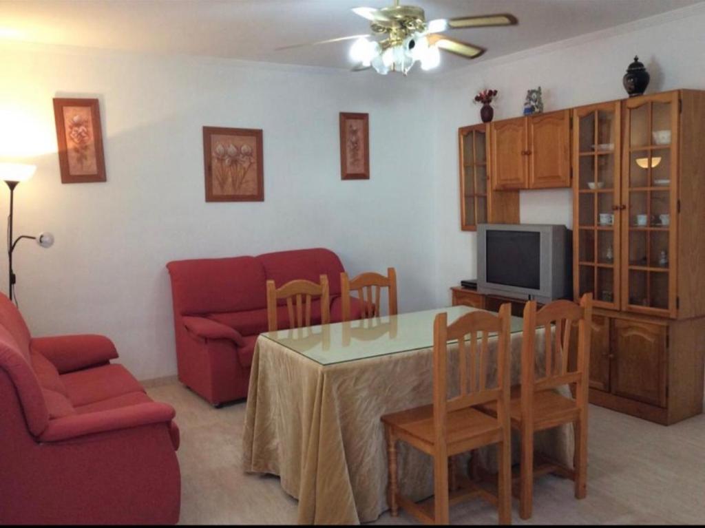 a living room with a table and a couch and a television at Alojamientos el cuco Luque in Luque