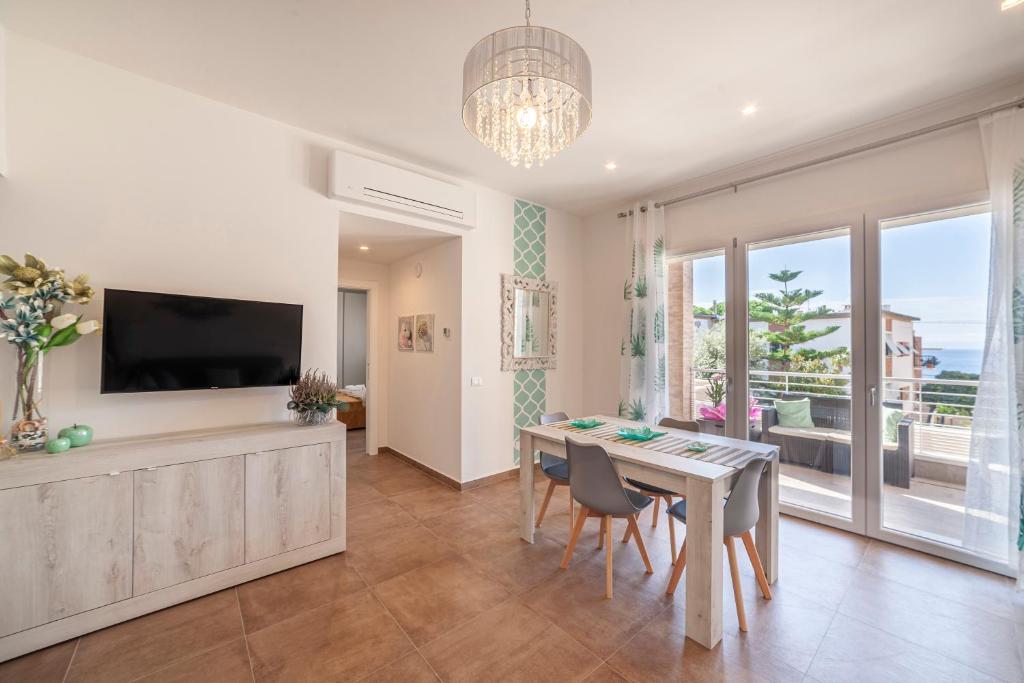 a living room with a dining table and a television at Prima dell'Elba Family Apartments in Piombino