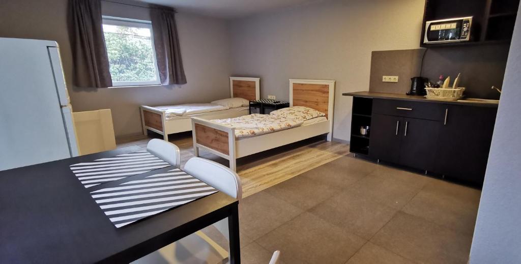 - un salon avec deux lits et une table dans l'établissement Hotel Engelsburg - Apartments, à Remscheid