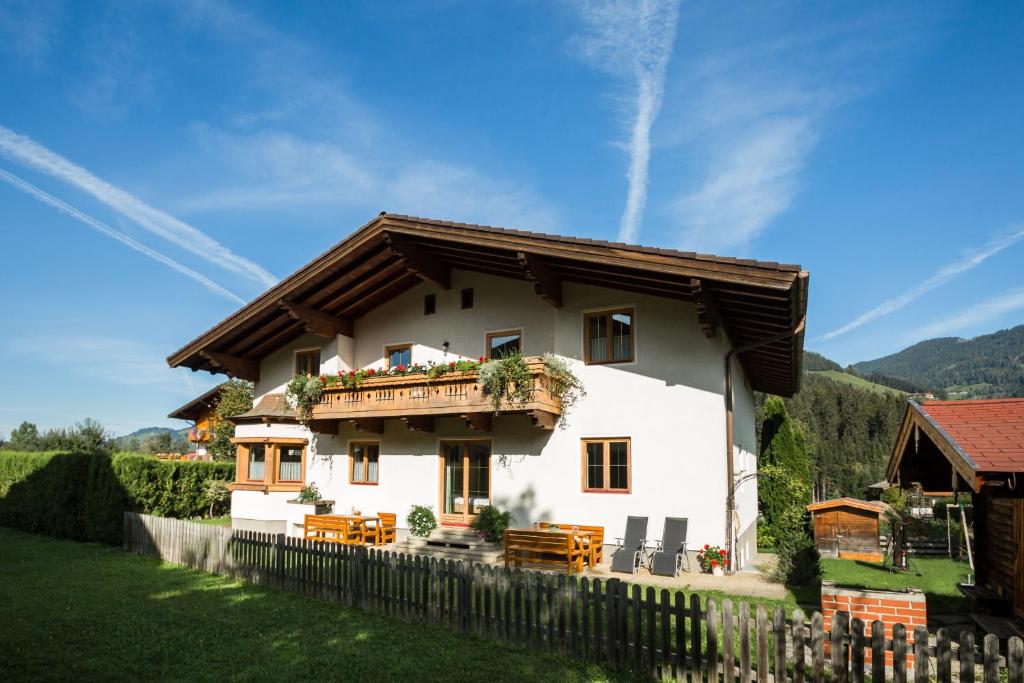 a large white house with a wooden balcony at DAS "Bergzeit" - Appartements in Wagrain