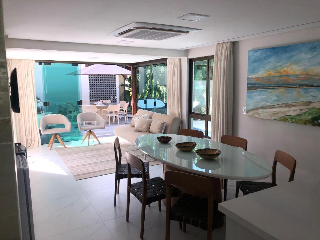 ein Wohnzimmer mit einem Tisch und einem Sofa in der Unterkunft Muro Alto Residence in Porto De Galinhas