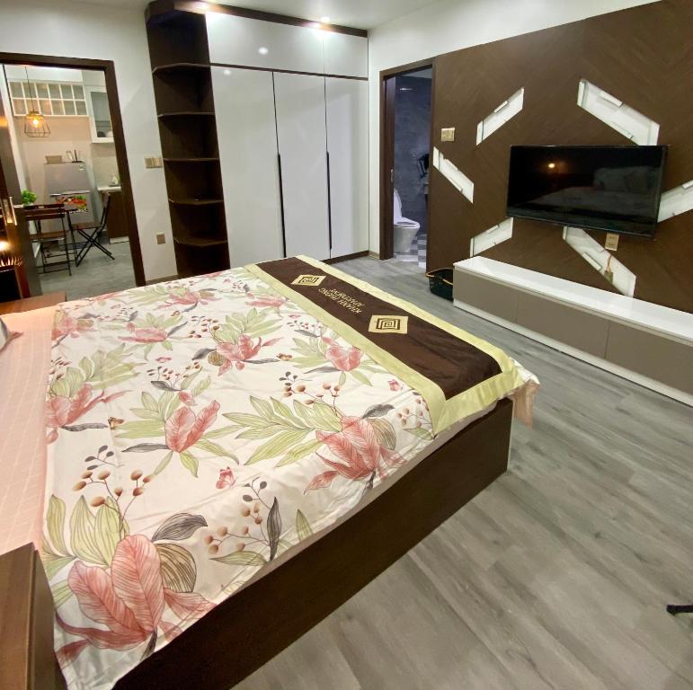 a bedroom with a bed with a flower pattern on it at Khánh Phong Apartment in Waterfront in Hai Phong