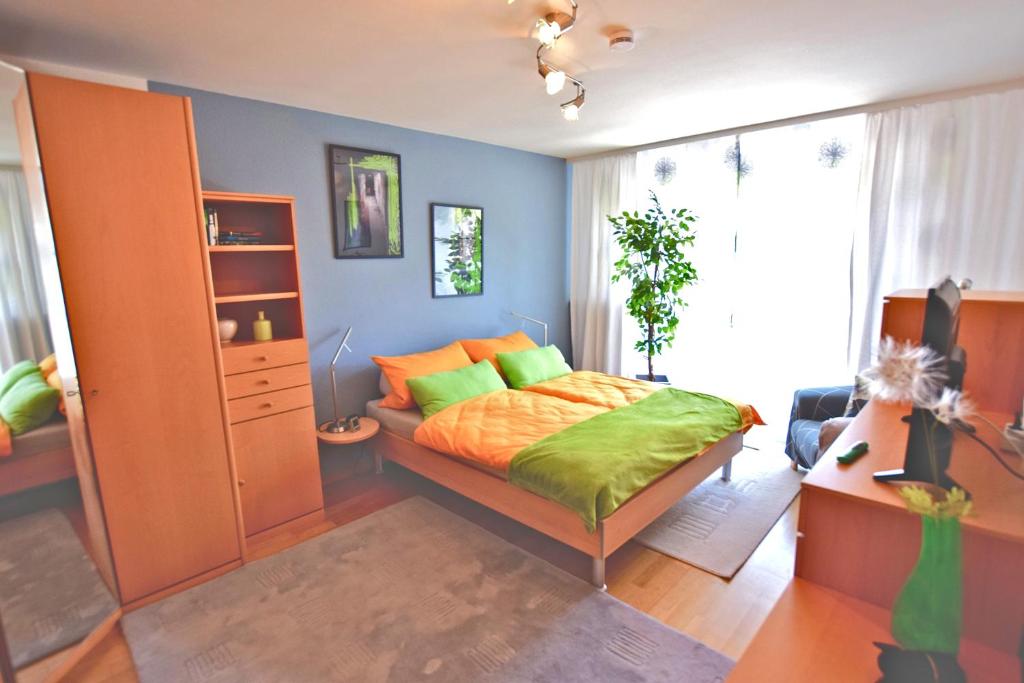 um quarto com uma cama com almofadas verdes e laranja em Rubin em Sinsheim
