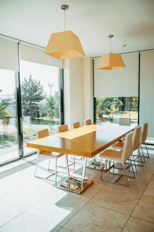 a dining room with a wooden table and chairs at Arfa Park-Hotel in Adler