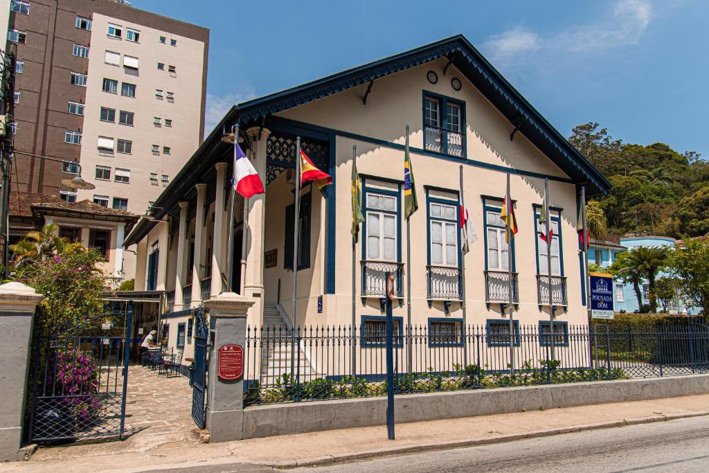 a building with flags on it on a street at Pousada Dom Petrópolis in Petrópolis