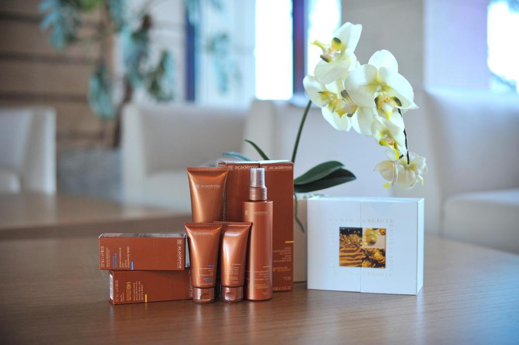 a table with books and a vase with white flowers at Arfa Park-Hotel in Adler