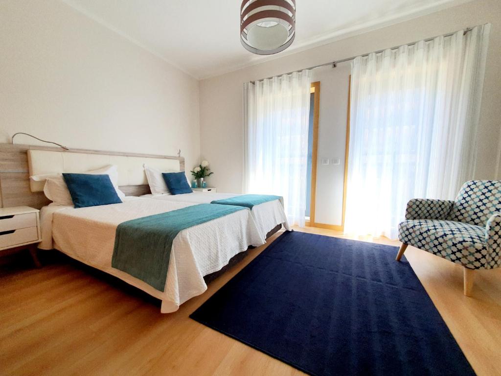 - une chambre avec un grand lit et un tapis bleu dans l'établissement Sovipral Homes Casa Marina, à Olhão