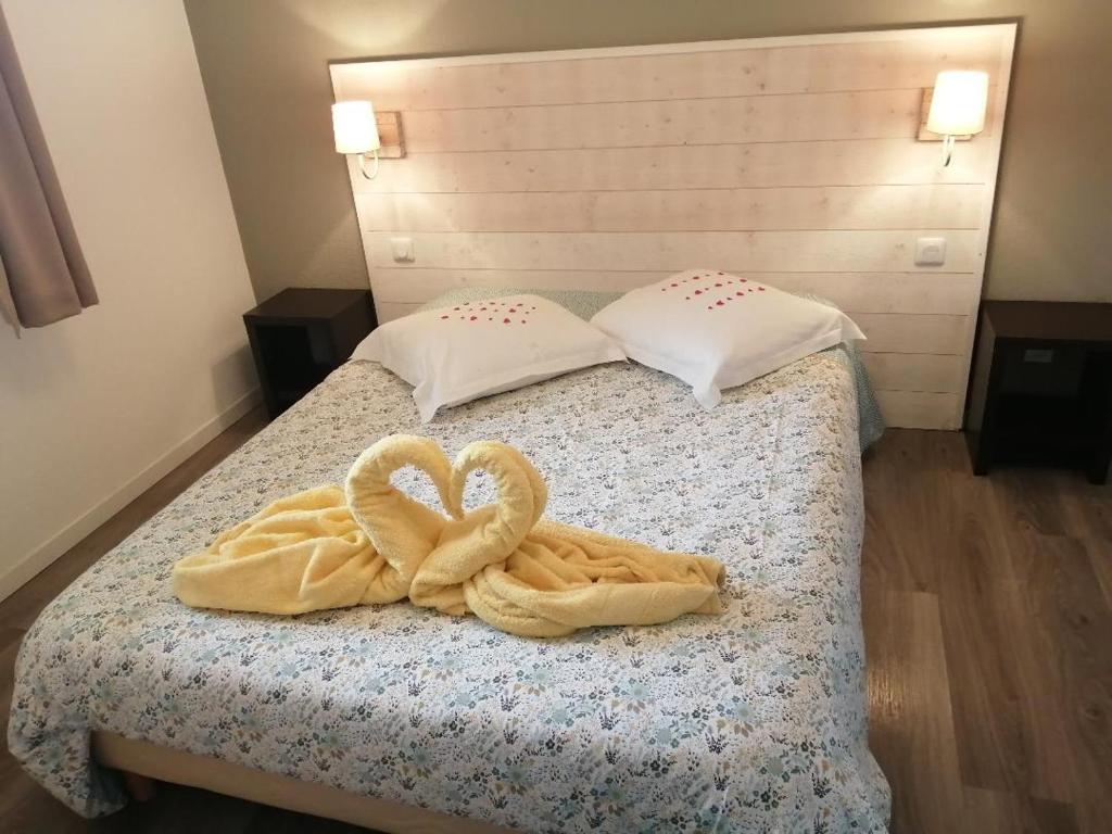 埃屈埃莫維爾的住宿－Le Fleur"H"on 11 d'Honfleur, T2 en Résidence avec Piscine, WIFI et Parking gratuits，床上有两条毛巾