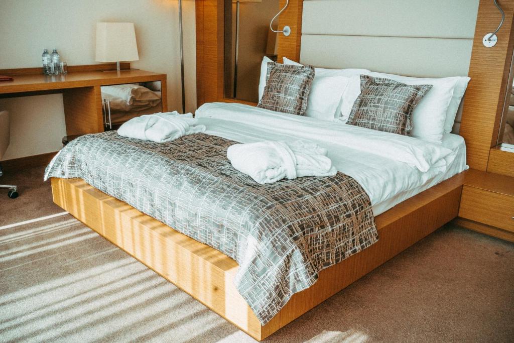 a bedroom with a large bed with towels on it at Arfa Park-Hotel in Adler
