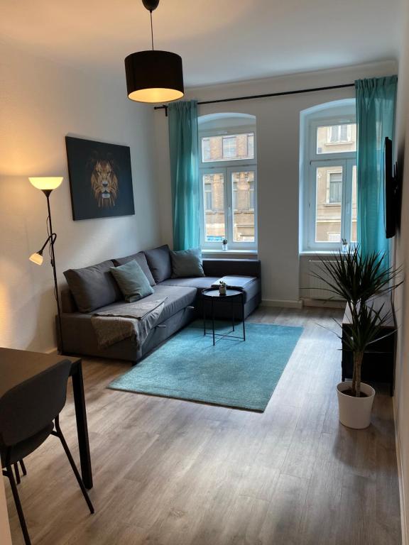 a living room with a couch and two windows at Leutzsch apartment in Leipzig