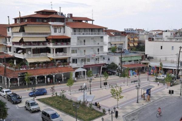 eine Stadtstraße mit Autos, die vor einem Gebäude geparkt sind in der Unterkunft Apartments Giotis in Paralia Katerinis